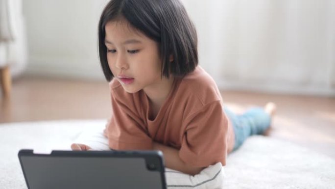 小女孩在家客厅用数字铅笔在数字平板电脑上画画