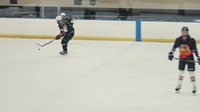 冰球队在加拿大的溜冰场练习进球策略和技巧。加拿大体育团体训练，在专业主场用棍棒和圆盘滑冰和比赛。