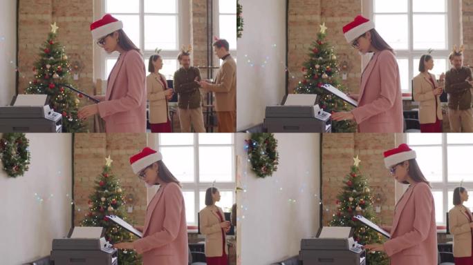 穿着圣诞老人帽子的女商人在办公室使用复印机