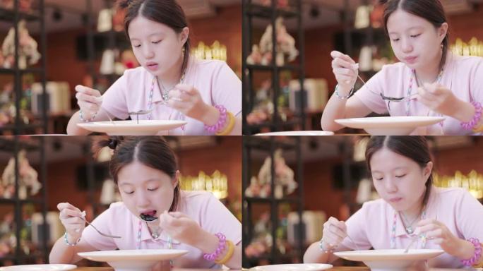 亚洲少女在餐厅吃意大利面