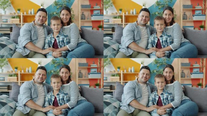 幸福家庭母亲的肖像，父亲和儿子坐在家里的沙发上微笑