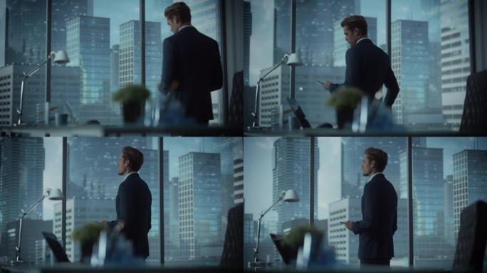 成功的年轻商人穿着西装站在他的现代办公室，使用智能手机，看着窗外的大城市的摩天大楼。成功的财务经理计