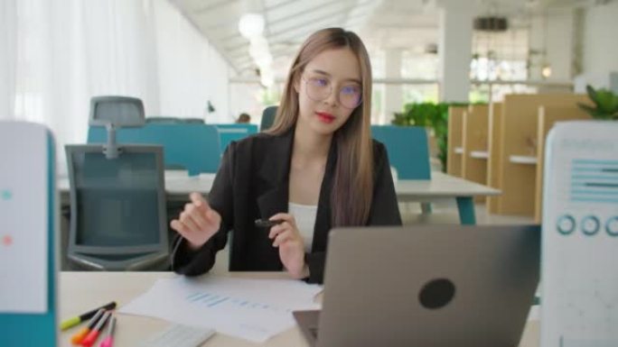 亚洲女商人打开笔记本电脑和工作数据分析项目文书工作。