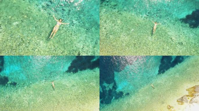 漂浮在亚得里亚海绿松石水上的空中女人