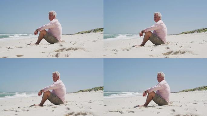 高个子白人坐在沙滩上欣赏美景