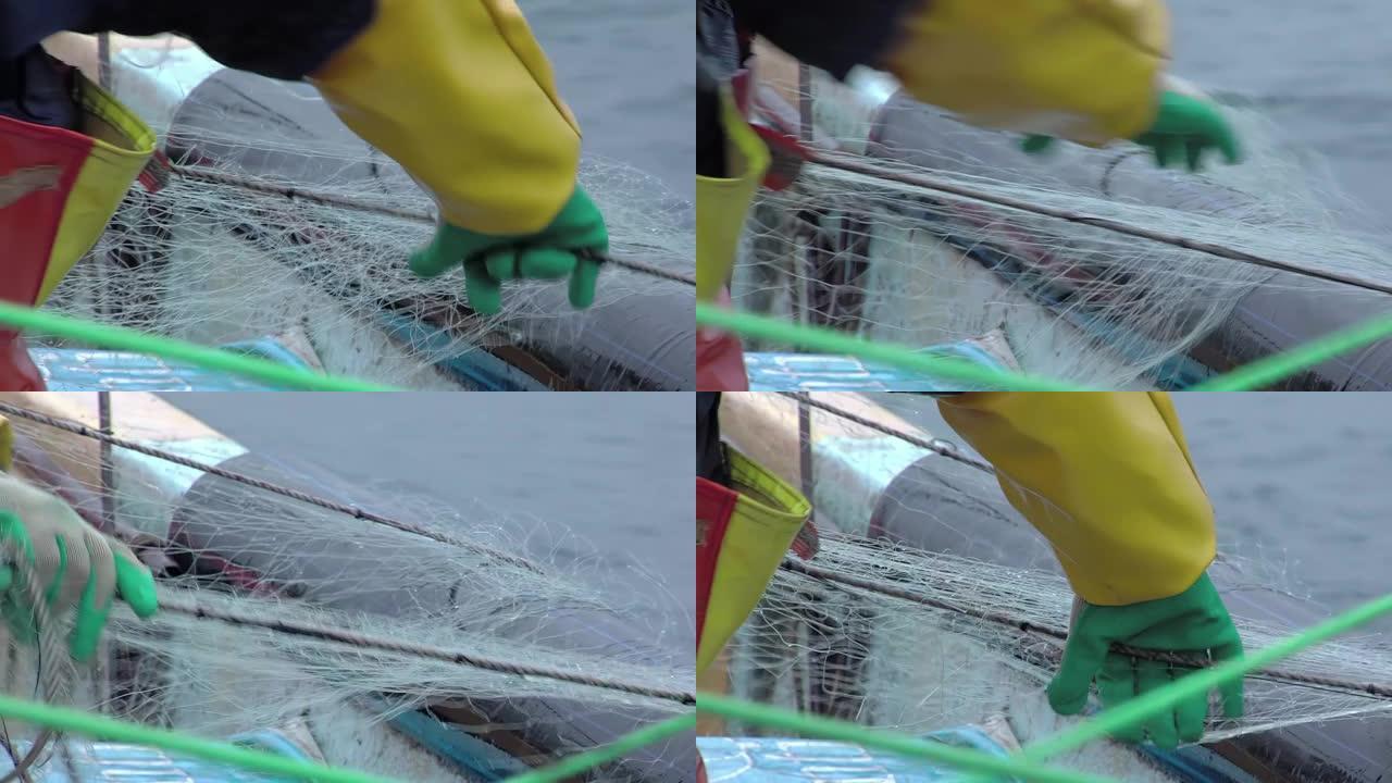 智利太平洋瓦尔帕莱索附近的一名男性渔民在船上戴着手套的渔网。特写。4k分辨率。