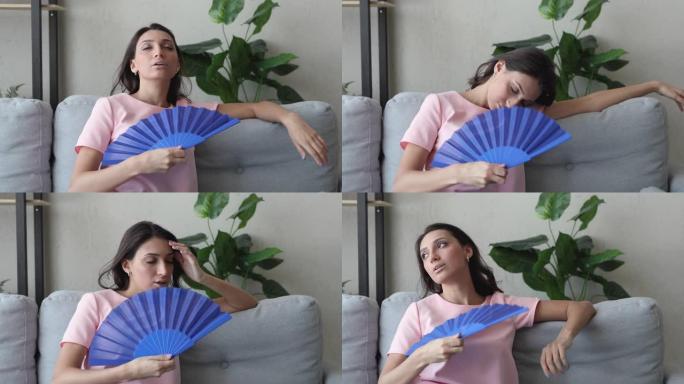 患有中暑的妇女使用风扇冷却自己