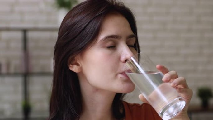 特写镜头年轻女子拿着玻璃饮用水