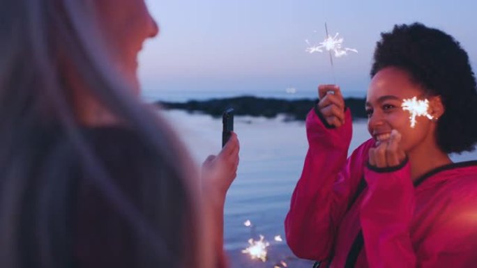 女人、朋友和海滩，晚上有火花，户外有庆祝和幸福。年轻人，电话和新年假期休假，旅行冒险和节日烟花。