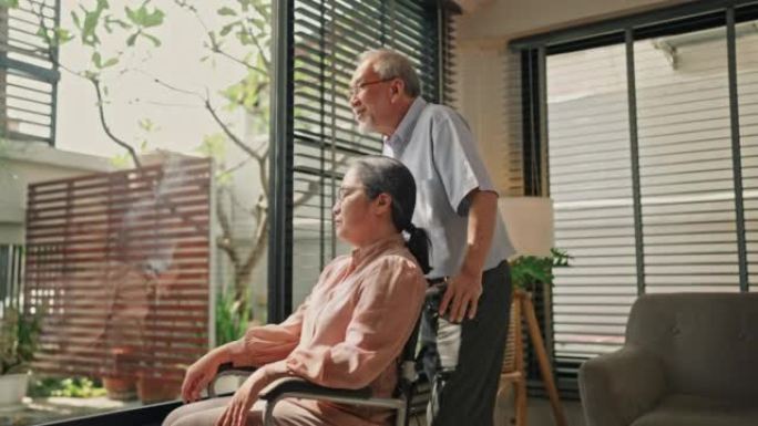 浪漫的高级丈夫拥抱坐在养老院轮椅上的残疾妻子。