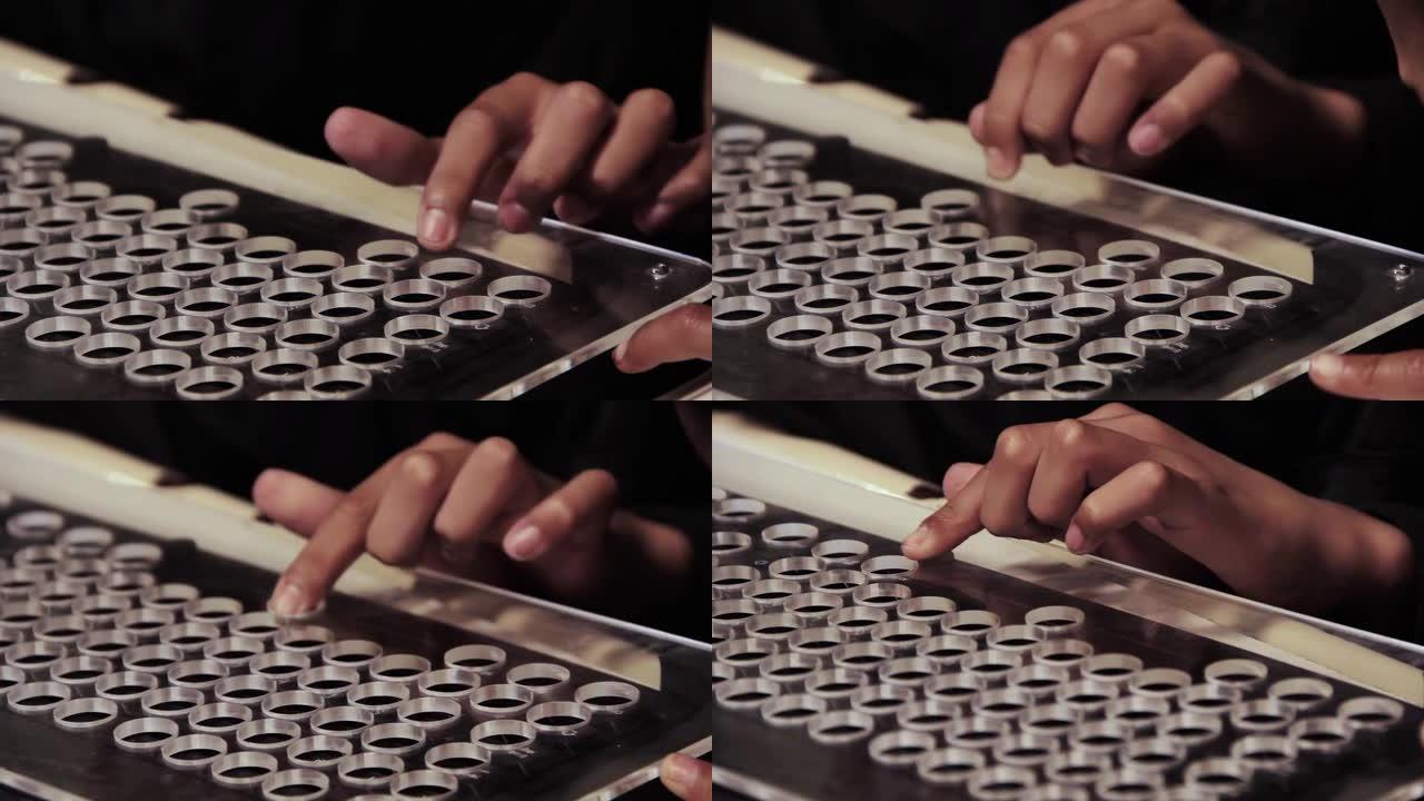 在学校课堂上，一个年轻的盲人学生的手触摸改编的计算机键盘。特写。4k分辨率。
