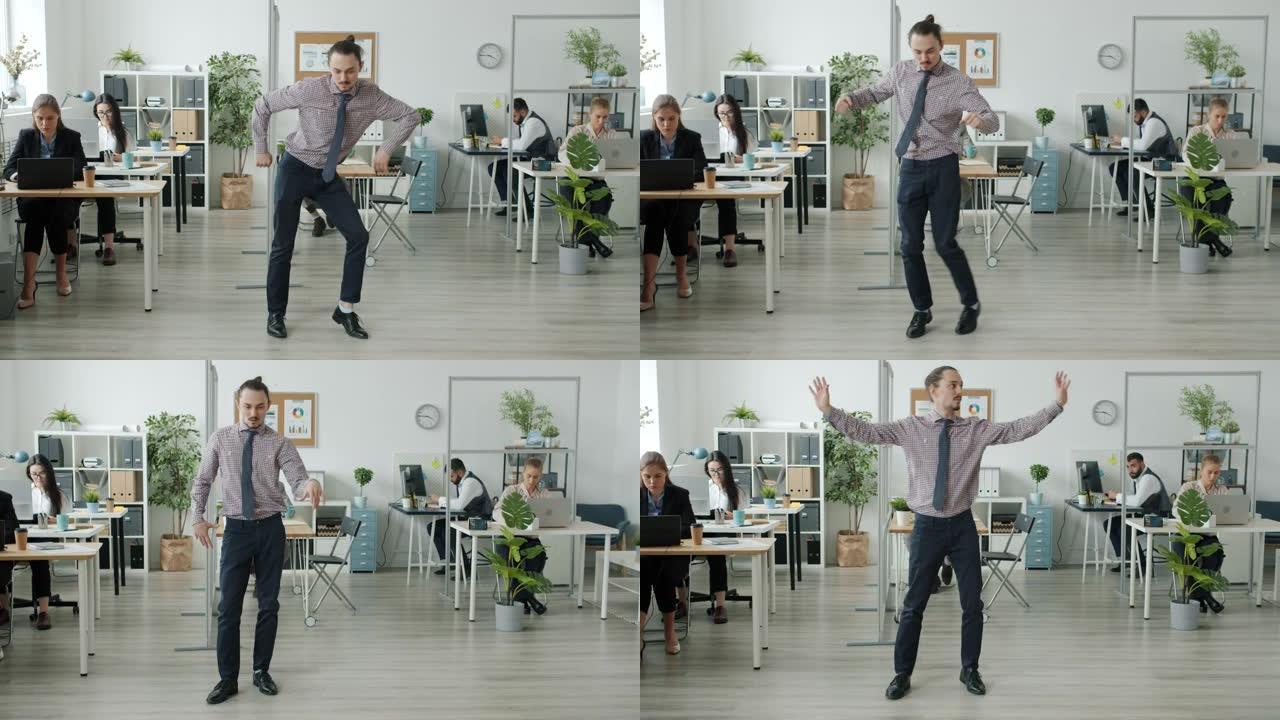 有趣的人在办公室跳舞的肖像，而商人在背景中工作
