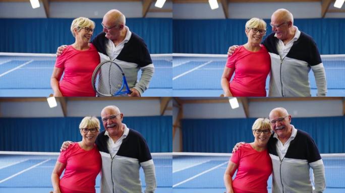 欢快的高级夫妇网球运动员站在球场上的肖像