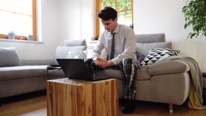 WS男子在家里举行视频会议时穿着衬衫，领带和睡衣