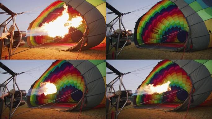 专业飞行员的慢动作正在为飞行前的彩色热气球充气设置火焰。