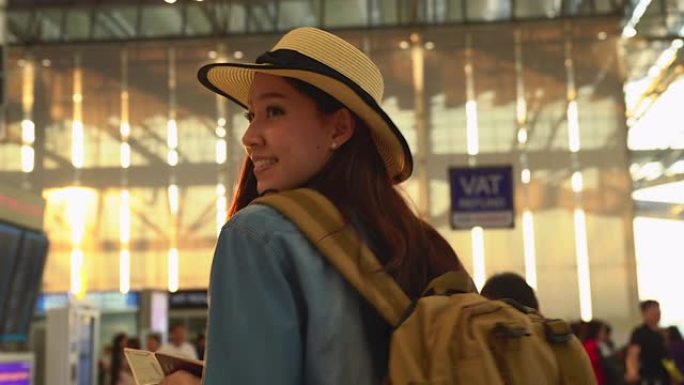 在候机楼机场门口行走的年轻休闲女子。年轻女子独自乘飞机旅行。