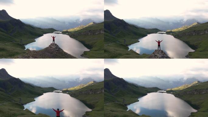 山顶上的男人徒步旅行者，有着美丽的湖泊和山脉背景