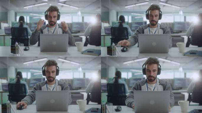 办公室: 微笑的IT程序员戴着耳机在台式计算机上工作的肖像。男性网站开发者，软件工程师开发应用程序，