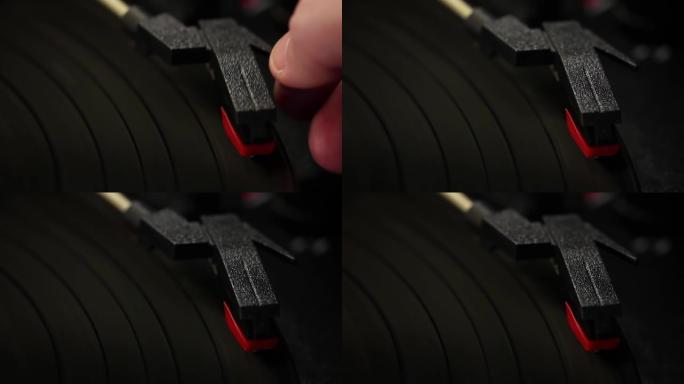 用手将电唱机的针放在旋转的黑胶唱片上。特写。4k分辨率。