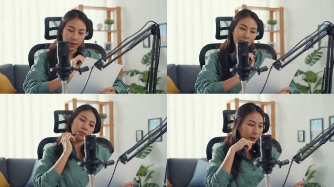 迷人的亚洲女孩唱片播客使用麦克风手持纸在她的房间里为音频博客谈话和复习主题创建内容。