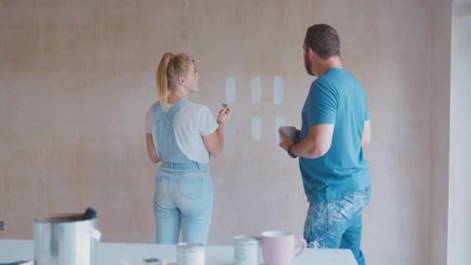 夫妇翻新厨房在家绘画测试仪在石膏墙上画彩色条-慢动作拍摄