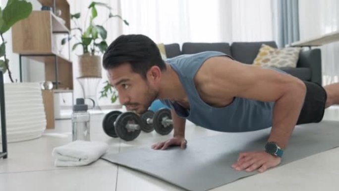 在家锻炼，强壮的男人在地板上锻炼在客厅和推举训练肌肉。健康的生活方式，减肥和力量动力。运动健康，表现