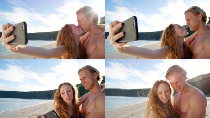 一对年轻夫妇在海滩上使用智能手机自拍的4k视频片段