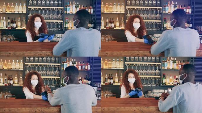 戴着口罩的咖啡馆女服务员正在接受NFC付款