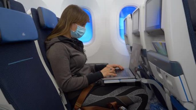 特写: 长途国际航班上的生产妇女正在使用笔记本电脑