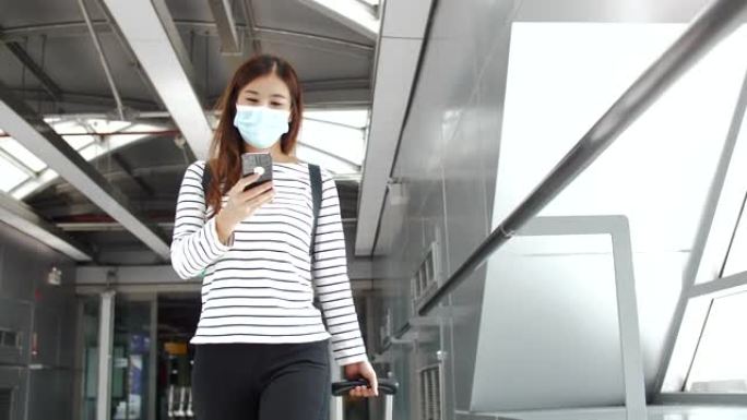 亚洲妇女戴着口罩进入机场航站楼