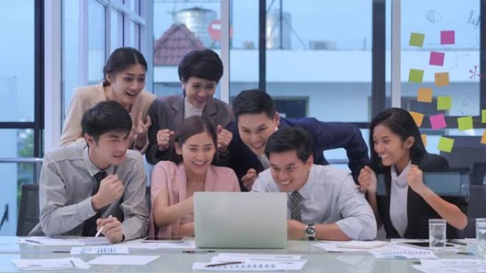 excite亚洲业务团队的工作乐趣在现代办公室中通过笔记本电脑技术一起进行视频通话时庆祝。团队合作概