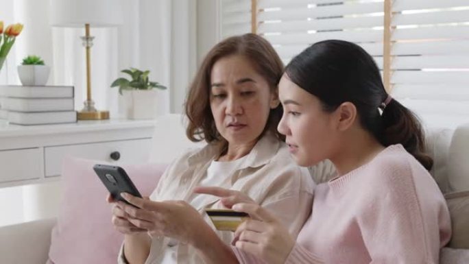亚洲家庭在线支付持有信用卡手机购物。