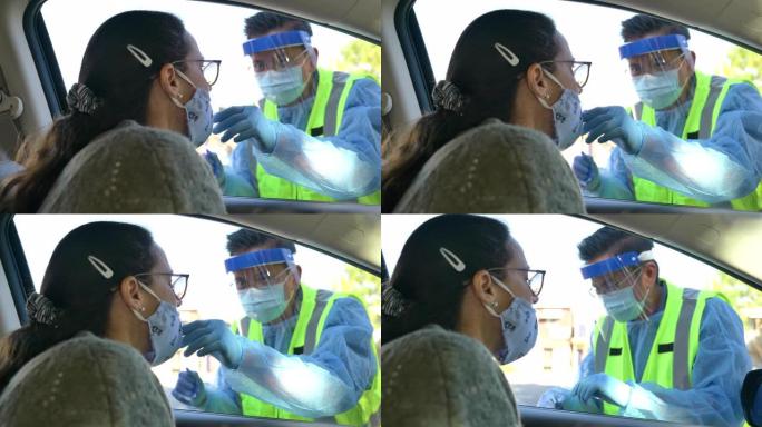 医疗专业人员在车里拿一个女人的鼻拭子