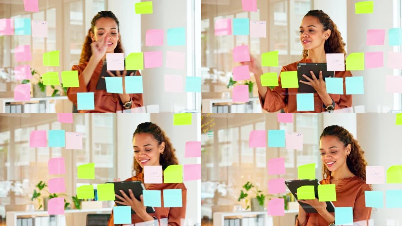 快乐的女性设计师在玻璃墙上规划创意，在创意和现代办公室里有彩色便签。忙碌的女人在头脑风暴项目和管理项