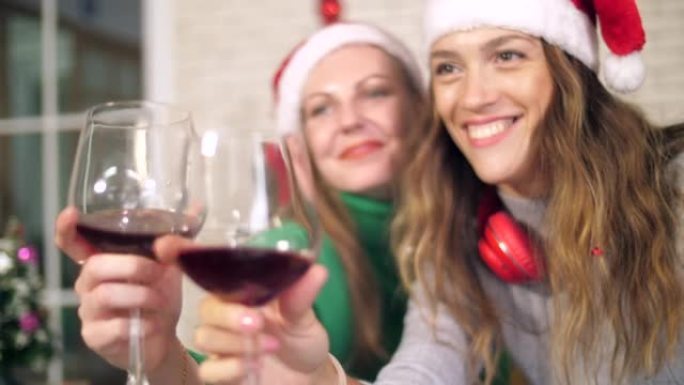 圣诞节活动中快乐的朋友喝红酒的近景