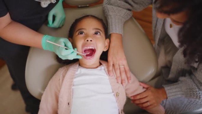 牙医在牙科预约期间检查小女孩的牙齿和口腔。孩子照镜子并进行检查以防止蛀牙和牙龈疾病。了解口腔和牙齿卫