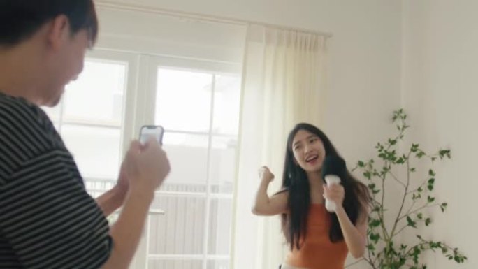 年轻人在与女友跳舞时拍摄音乐并在家跳舞。