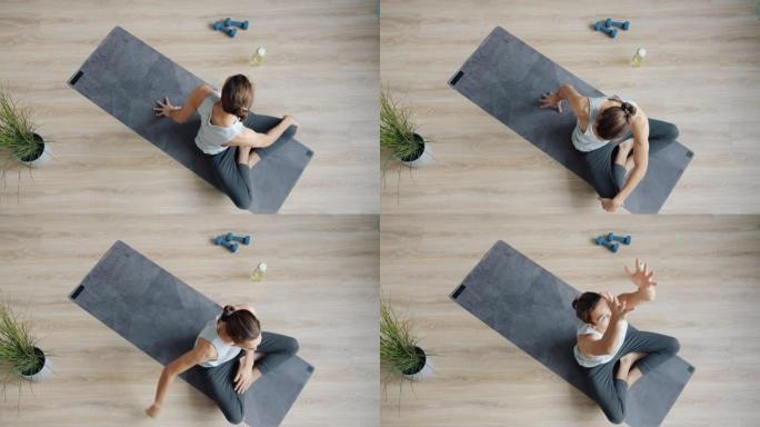 现代工作室中年轻运动员在垫子上享受瑜伽练习的俯视图慢动作