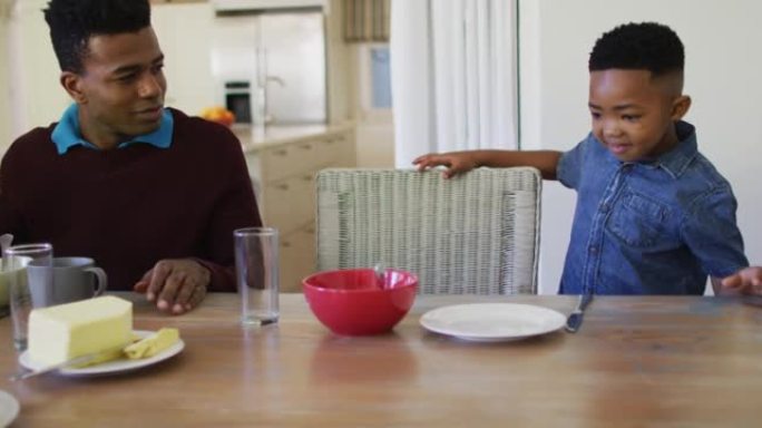 非裔美国男孩和家人坐在餐桌上一起在家吃早餐