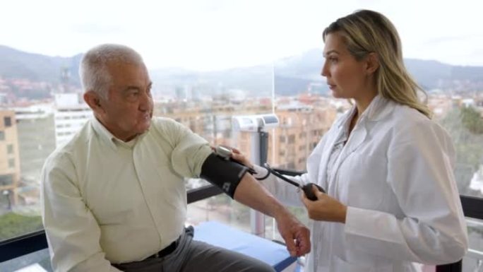 拉丁美洲女医生检查一名高级男子并测量其血压