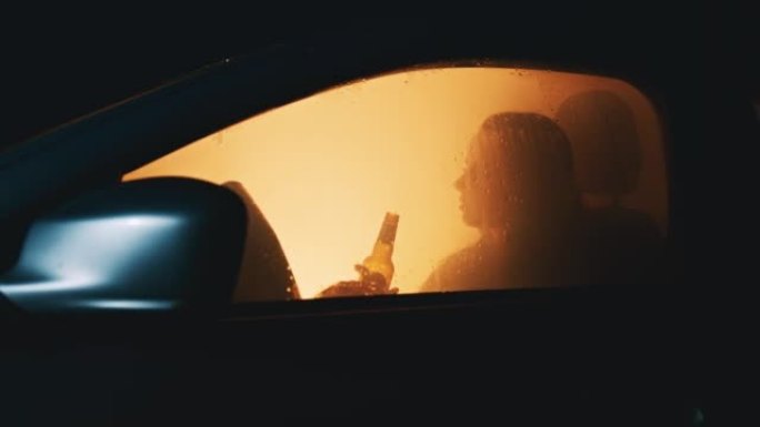 孤独的年轻女子坐在车里喝啤酒
