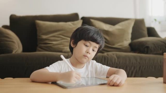 男婴在家用数字平板电脑做作业。