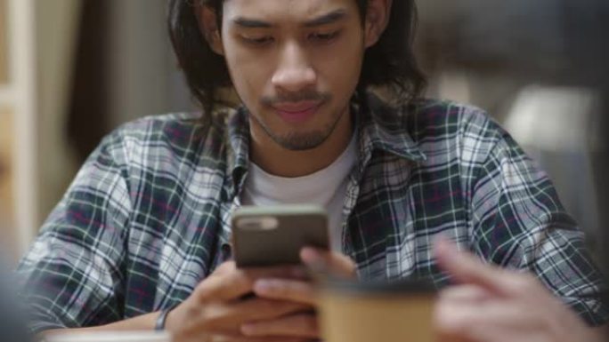 亚洲男子短信社交媒体在夜间酒吧的电话。