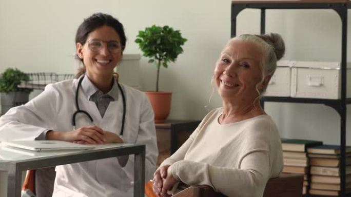 快乐的60多岁妇女与微笑的年轻医生合影。