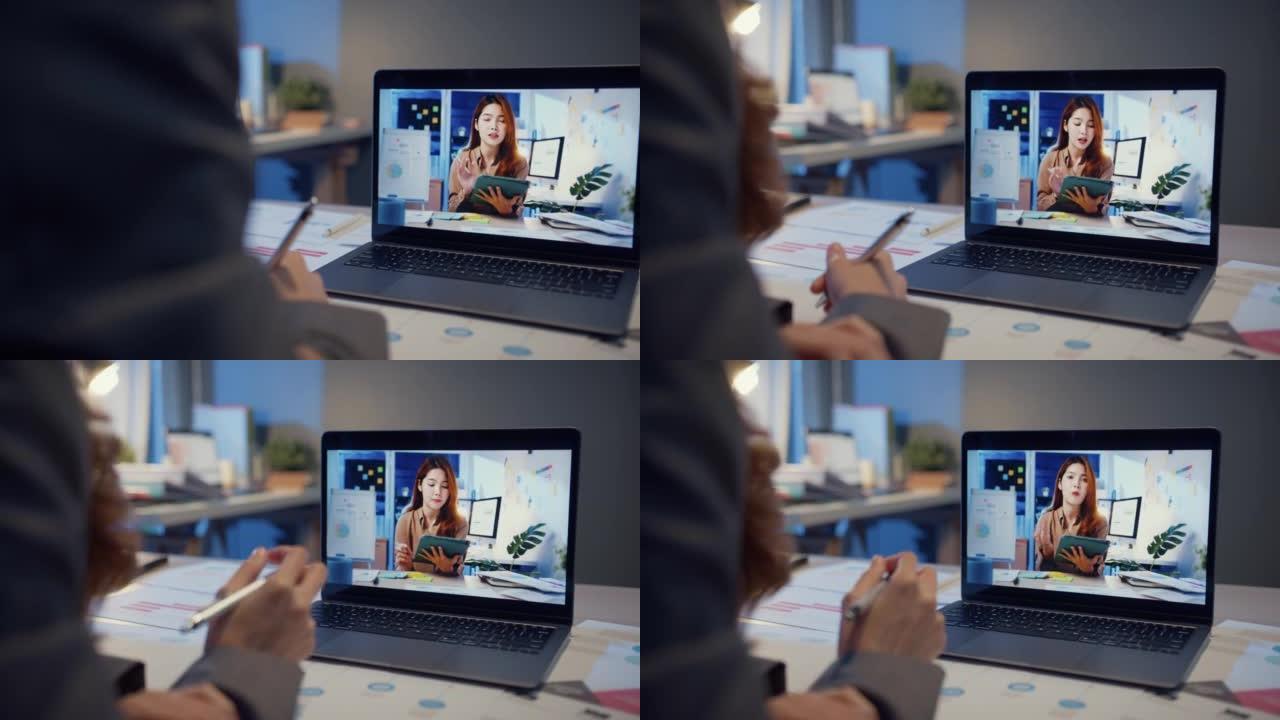 亚洲女商人使用笔记本电脑与同事讨论在家客厅视频通话会议的计划。夜间超负荷工作，远程，社交距离，检疫冠