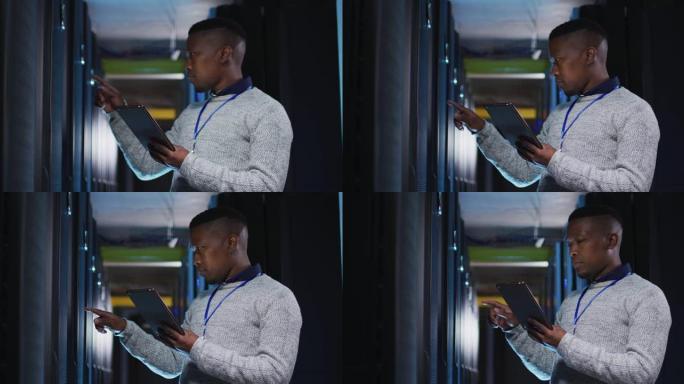非裔美国男性计算机技术员使用平板电脑在商务服务器机房工作