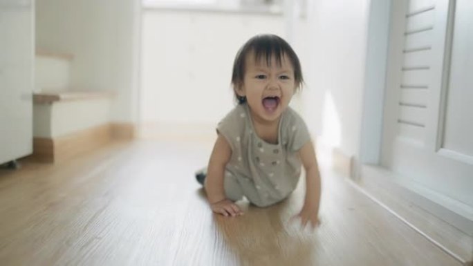 小女孩在她的房子里快乐地练习走路和爬行。