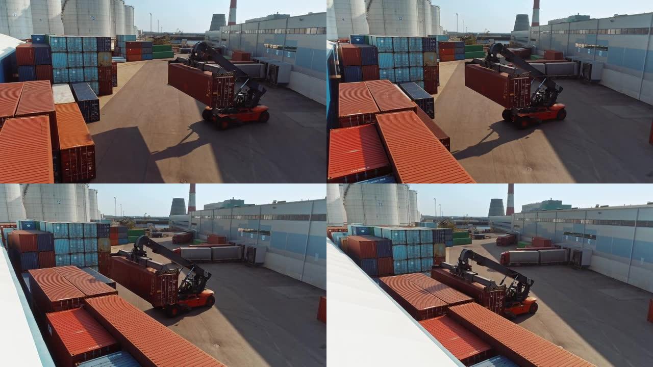 在造船厂码头中，一名集装箱搬运工在运送大型红色货运集装箱的空中无人机镜头。机器的驾驶员正在物流中心仓