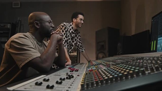 两个年轻人在工作室创作和录制新音乐