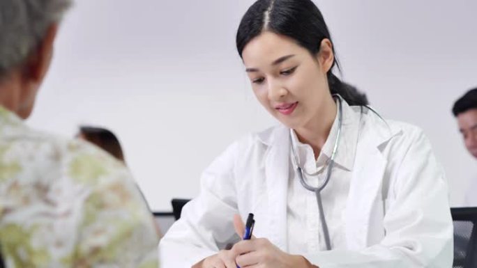 亚洲青年女护士医生的快乐团体志愿者为亚洲老年妇女检查心脏，以预防流行病并为亚洲患者提供咨询。医疗，护